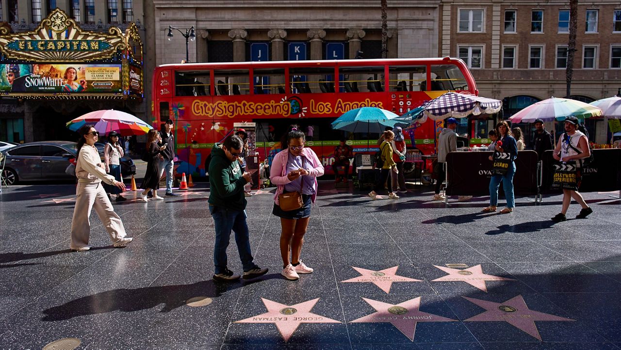 Tourists walk along the Hollywood Walk of Fame in Los Angeles, Friday, April 4, 2025. (AP Photo/Jae C. Hong)