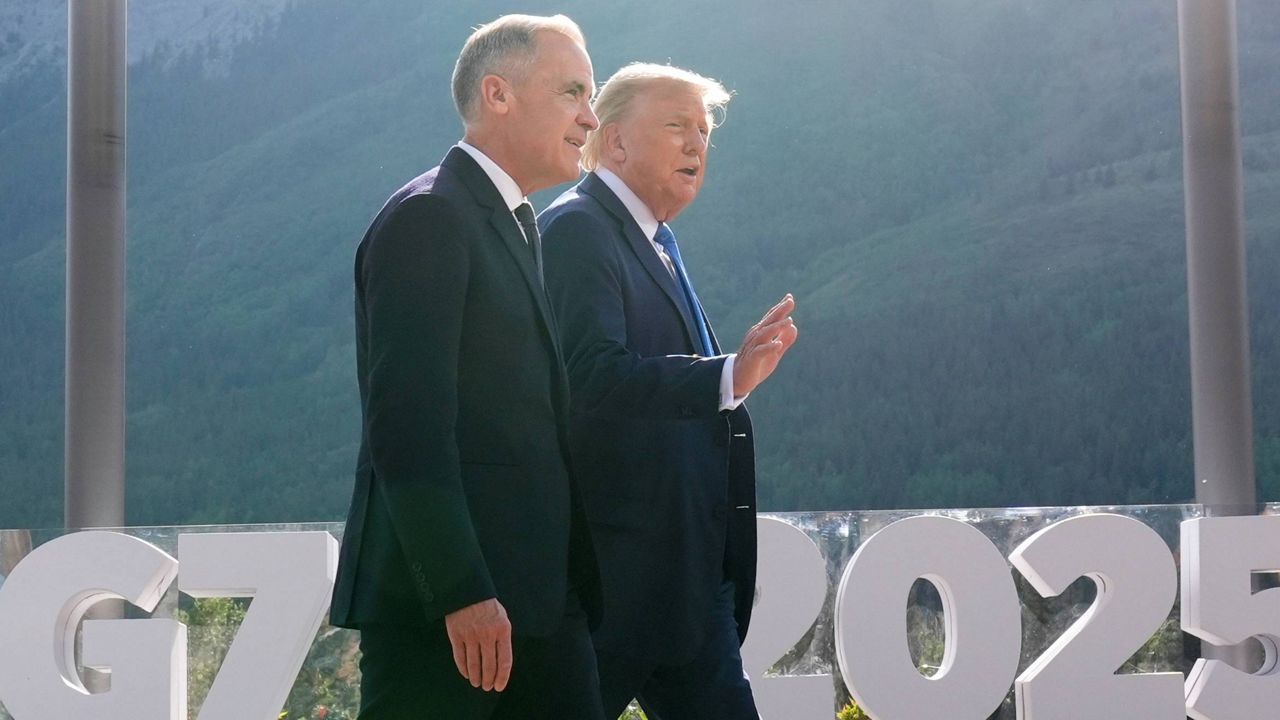 Canada's Prime Minister Mark Carney walks with President Donald Trump after a group photo at the G7 Summit, Monday, June 16, 2025, in Kananaskis, Canada. (AP Photo/Mark Schiefelbein)