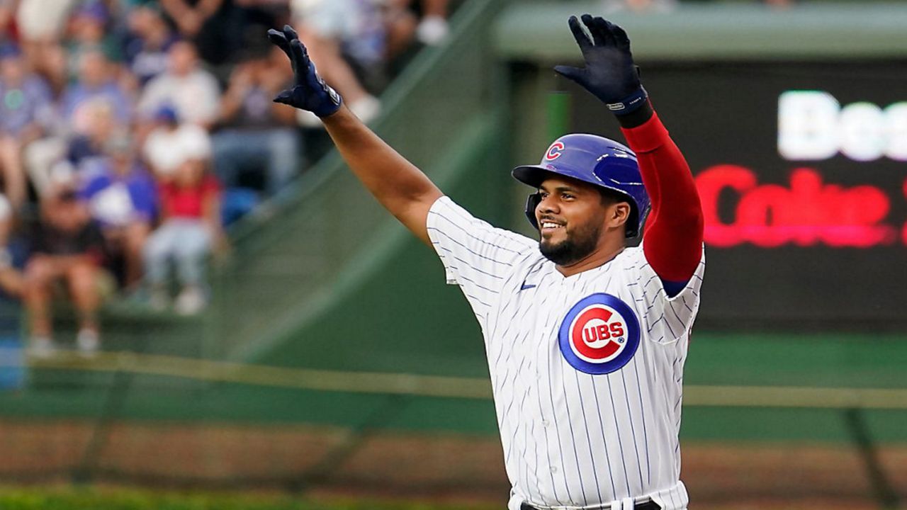 Chicago Cubs' Jeimer Candelario celebrates his single off Cincinnati Reds starting pitcher Ben Lively, after joining the Cubs in a trade with the Washington Nationals, during the first inning of a baseball game Tuesday, Aug. 1, 2023, in Chicago.