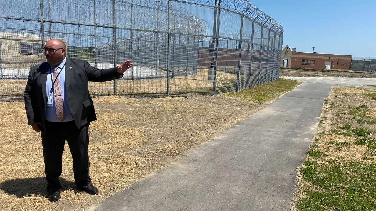 Tony Cantillo, deputy commissioner of the Maine Department of Corrections, describes the grounds of the new Maine Corrections Center in Windham. In the background is tilled dirt that will function as a gardening space for residents. (Spectrum News/Sean Murphy)