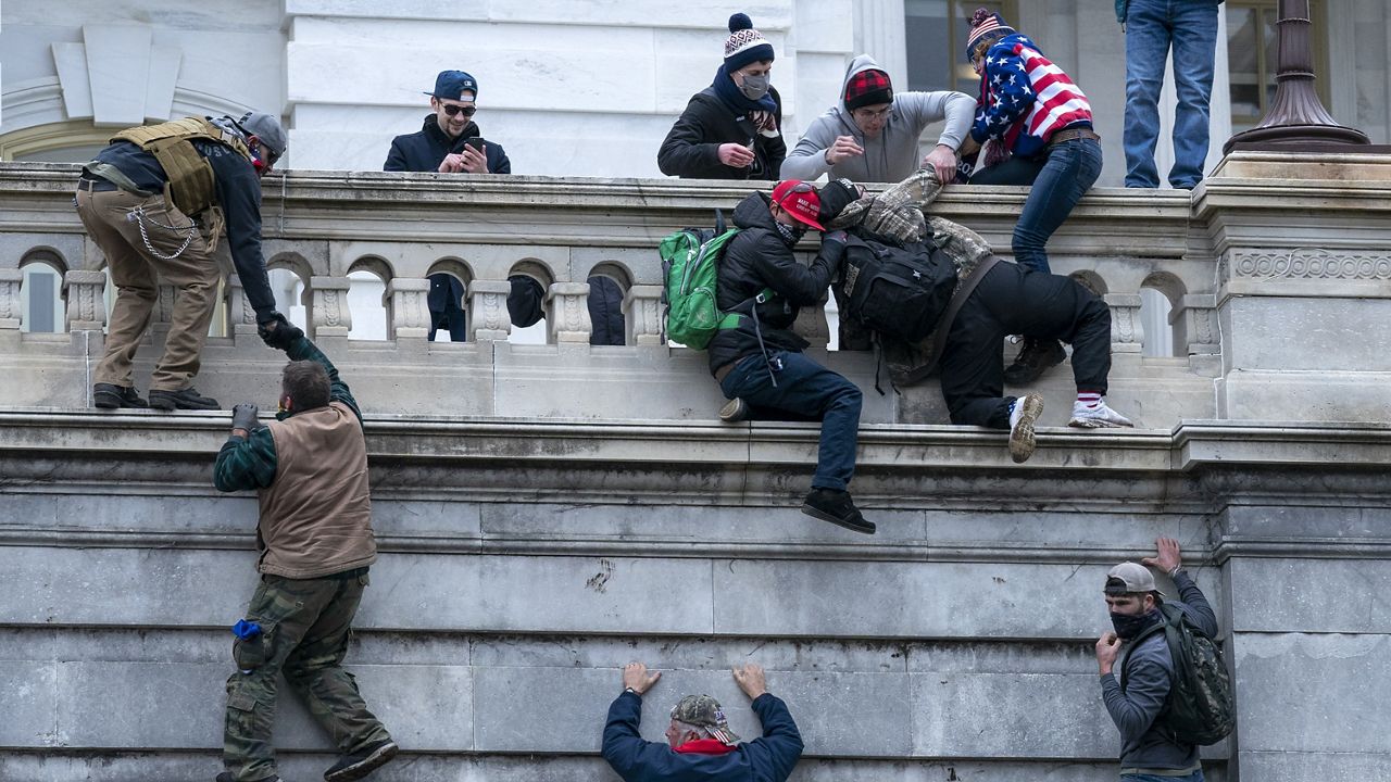 Rioters loyal to President Donald Trump climb the west wall of the the U.S. Capitol, Jan. 6, 2021, in Washington. (AP Photo/Jose Luis Magana, File)