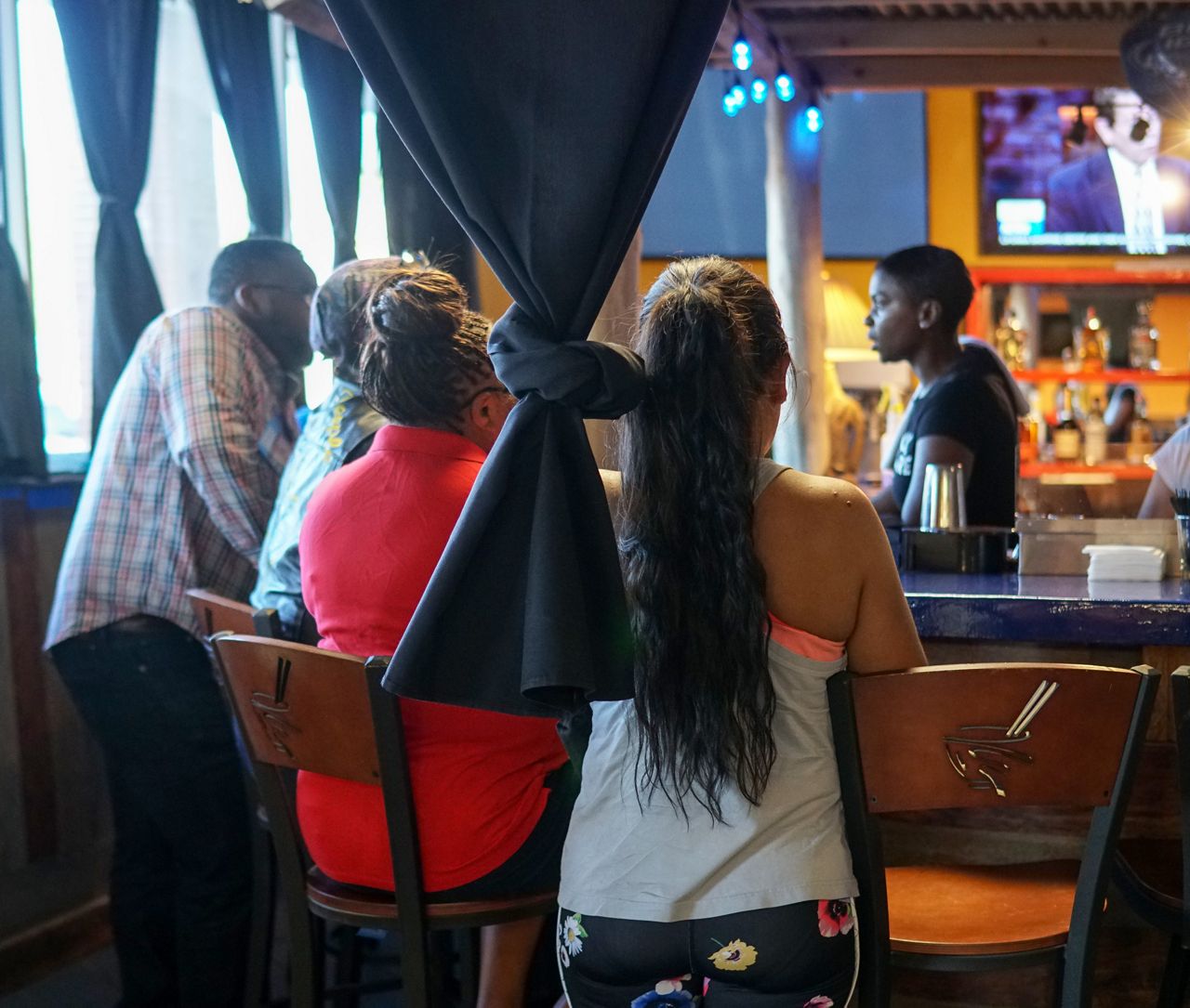 A closeup of people ordering food at a bar