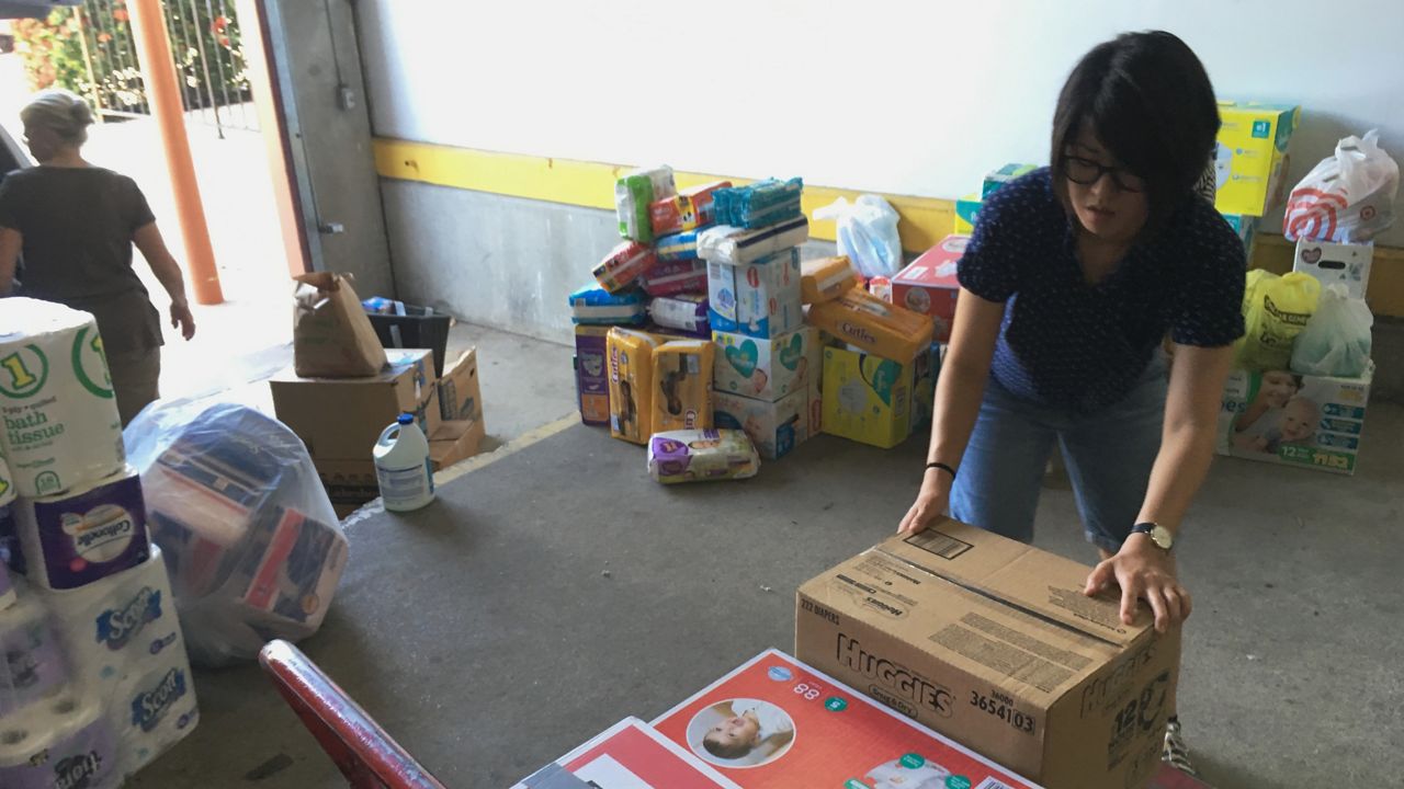 Catholic Charities of the Rio Grande Valley volunteer Veronica Yoo loads boxes of donations on to a cart at a storage facility in McAllen, Texas on June 24, 2018. (AP Photo/Manuel Valdes, File)