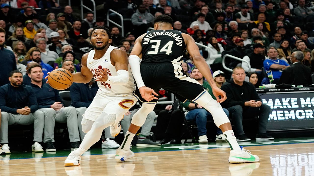 Cleveland Cavaliers' Donovan Mitchell, left, drives to the basket against Milwaukee Bucks' Giannis Antetokounmpo (34) during the first half of an NBA basketball game Friday, Jan. 26, 2024, in Milwaukee.