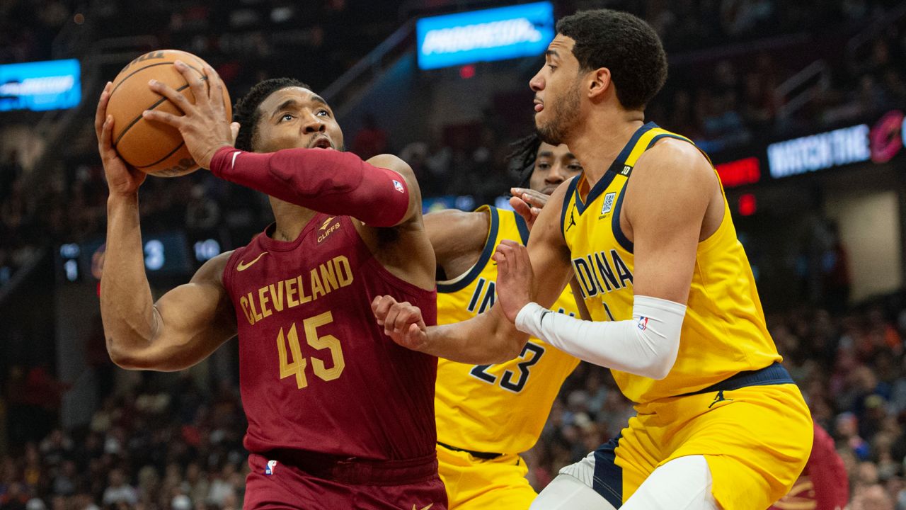 Cleveland Cavaliers' Donovan Mitchell (45) looks to shoot as Indiana Pacers' Tyrese Haliburton, right, defends during the first half of an NBA basketball game in Cleveland, Friday, April 12, 2024. (AP Photo/Phil Long)
