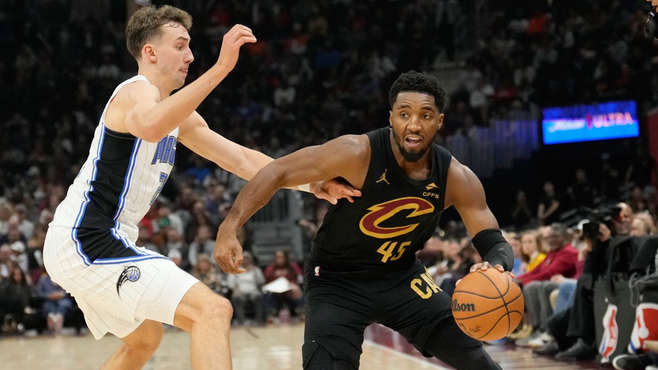 Cleveland Cavaliers guard Donovan Mitchell (45) drives past Orlando Magic forward Franz Wagner, left, in the first half of an NBA game, Friday, Nov. 1, 2024, in Cleveland.