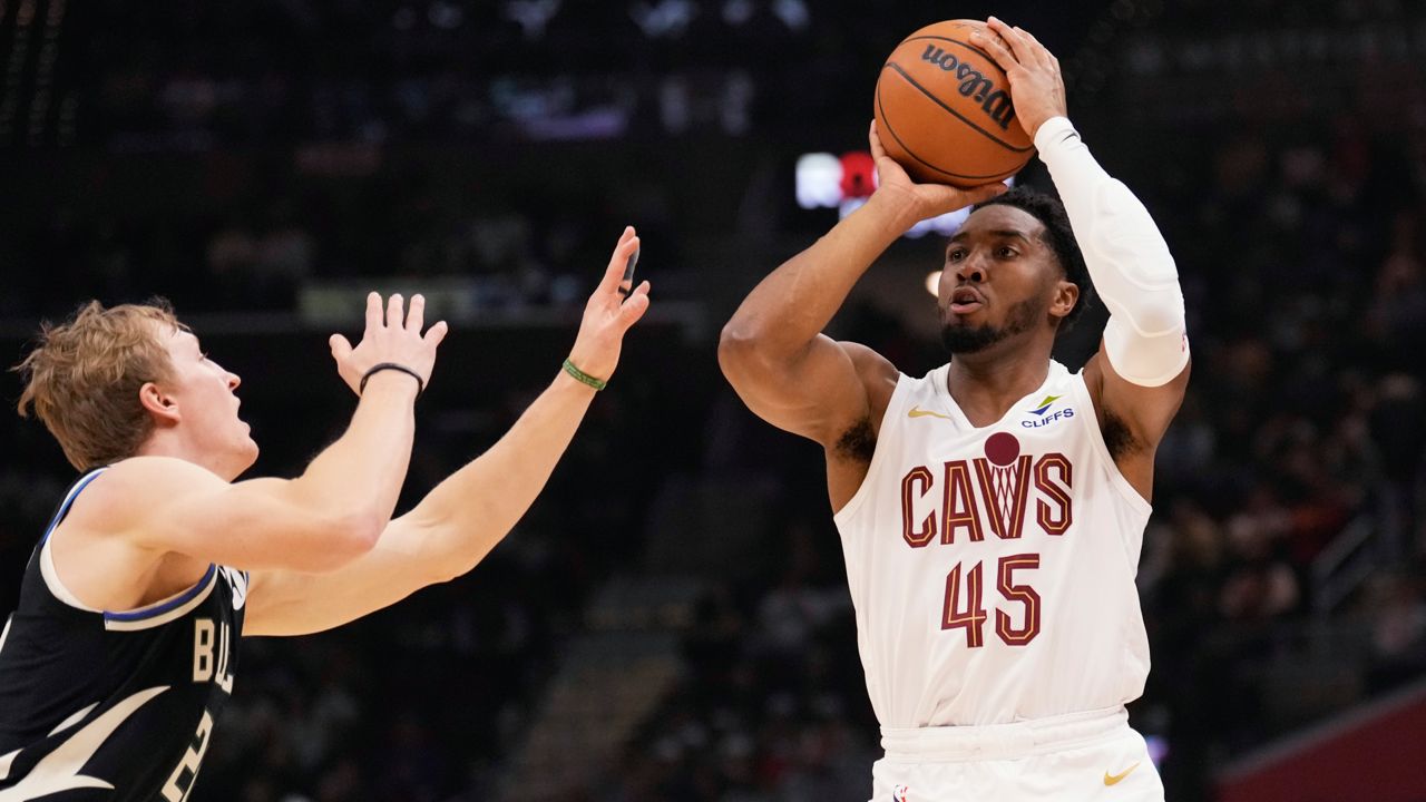 Cleveland Cavaliers guard Donovan Mitchell (45) shoots over Milwaukee Bucks guard AJ Green, left, in the first half of an NBA basketball game, Friday, Dec. 20, 2024, in Cleveland. 