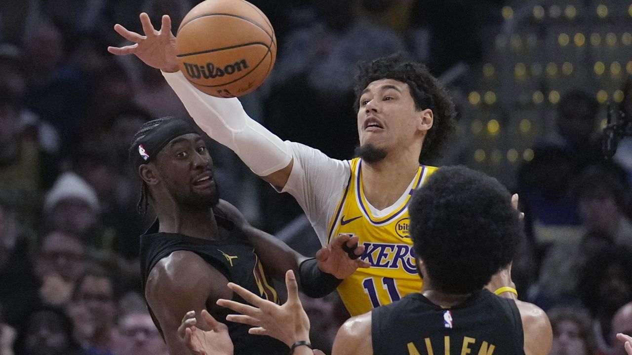 Los Angeles Lakers center Jaxson Hayes (11) reaches for the ball between Cleveland Cavaliers guard Caris LeVert, left, and center Jarrett Allen (31) in the first half of an NBA basketball game, Wednesday, Oct. 30, 2024, in Cleveland. (AP Photo/Sue Ogrocki)