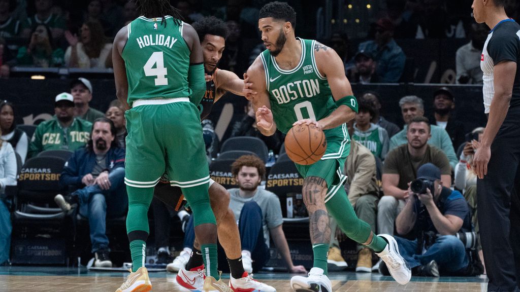 Boston Celtics guard Jrue Holiday (4) provides a screen for teammate forward Jayson Tatum (0) who drives during the first half of an NBA basketball game against the Washington Wizards in Washington, Sunday, March 17, 2024. (AP Photo/Manuel Balce Ceneta)