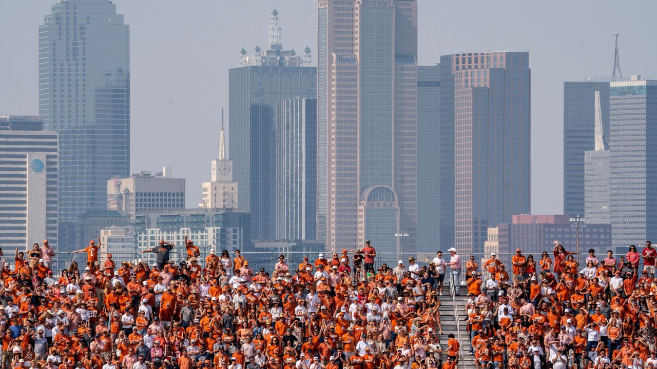 The Dallas skyline rises behind the Cotton Bowl stands as Texas fans watch during the first half of an NCAA college football game against Oklahoma at the Cotton Bowl, Saturday, Oct. 8, 2022, in Dallas. (AP Photo/Jeffrey McWhorter, File)