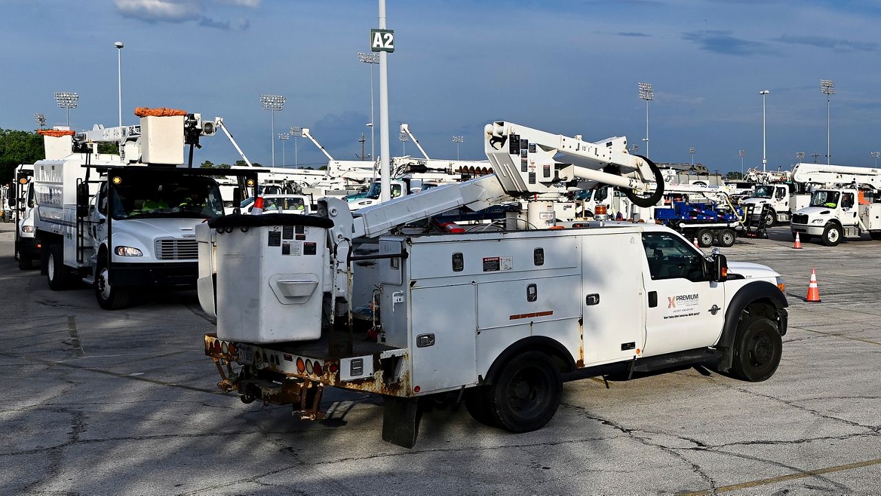 Utility trucks sit parked at a CenterPoint Energy staging center at the Houston Race Track in Houston, Wednesday, July 10, 2024. (AP Photo/Maria Lysaker)