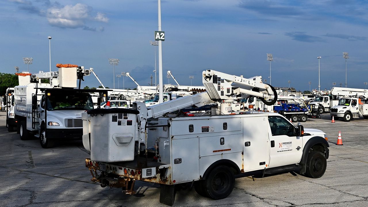 Utility trucks sit parked at a CenterPoint Energy staging center at the Houston Race Track in Houston, Wednesday, July 10, 2024. Millions of residents lost power after Hurricane Beryl made landfall. (AP Photo/Maria Lysaker)