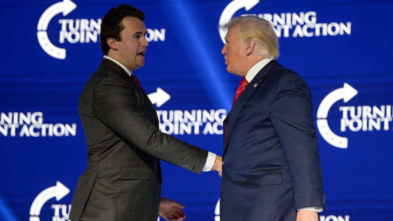Former President Donald Trump, right, shakes hands with Turning Point CEO Charlie Kirk before speaking during the Turning Point USA Student Action Summit, July 23, 2022, in Tampa, Fla. (AP Photo/Phelan M. Ebenhack, File)