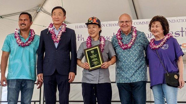 Chef Hyun Kim of O’Kims Korean Kitchen (center) received the Entrepreneur of the Year award at the 19th Annual Korean Festival held over the weekend. (Photo courtesy of O’Kims Korean Kitchen)