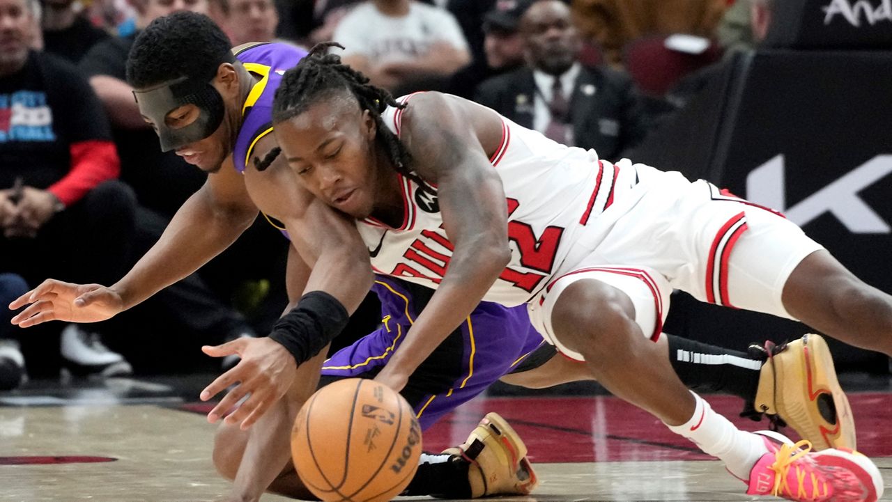 Chicago Bulls guard Ayo Dosunmu, right, battles for a loose ball against Los Angeles Lakers forward Rui Hachimura during the second half of an NBA basketball game in Chicago, Wednesday, Dec. 20, 2023. The Bulls won 124-108. (AP Photo/Nam Y. Huh)