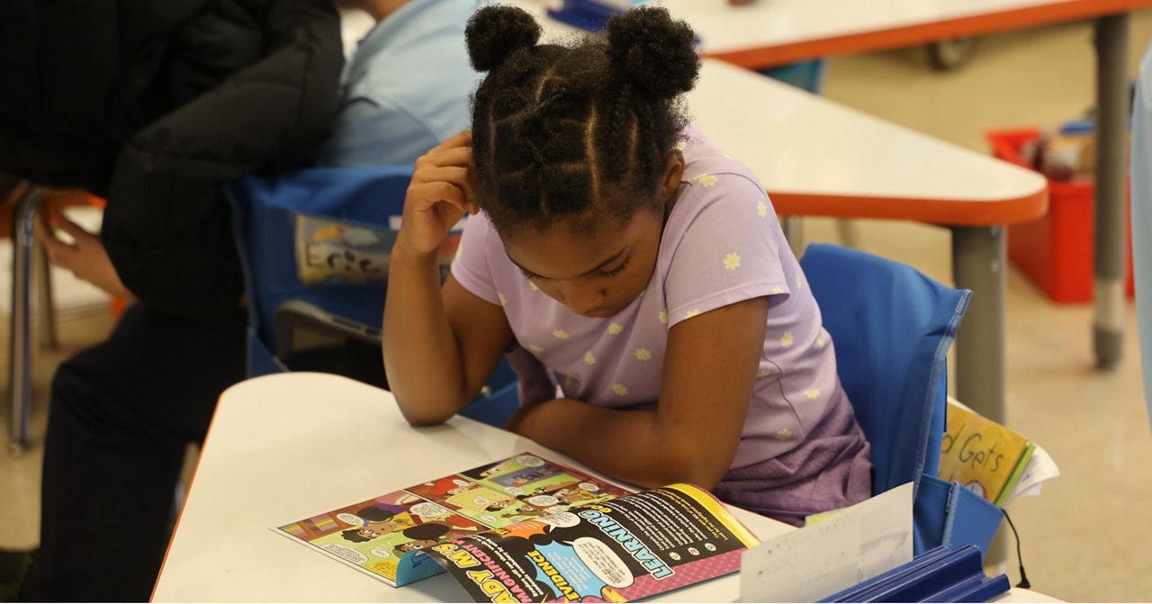 A St. Louis Public Schools (SLPS) student reads her copy a comic book from a collection “Drawn In.” The animated stories are set in a bustling Midwestern city about four kids who use problem-solving and literacy skills to save the world from cartoon mayhem. (Photo courtesy of SLPS Facebook Page)