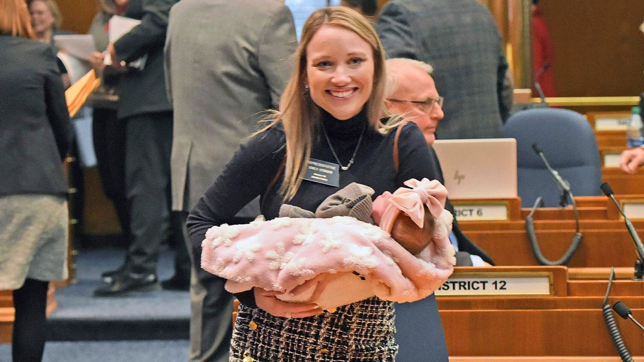Rep. Emily O'Brien R-Grand Forks carries daughter Jolene Green, 3 weeks, into the House chamber, Dec. 6, 2022, in Bismarck, N.D. Last year, the state representative helped persuade her colleagues to approve $66 million in child care spending proposed by Gov. Doug Burnum, a Republican. O'Brien argued it could help the state's workforce shortage by helping more parents go to work. (Tom Stromme/The Bismarck Tribune via AP)