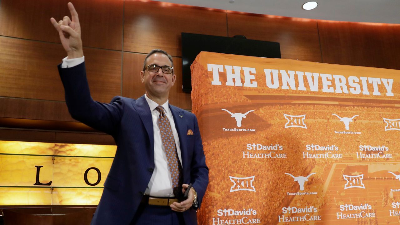 Chris Del Conte holds up the Hook'em sign at a news conference where he was introduced at the new vice president and athletics director for the University of Texas, Monday, Dec. 11, 2017, in Austin, Texas. (AP Photo/Eric Gay)