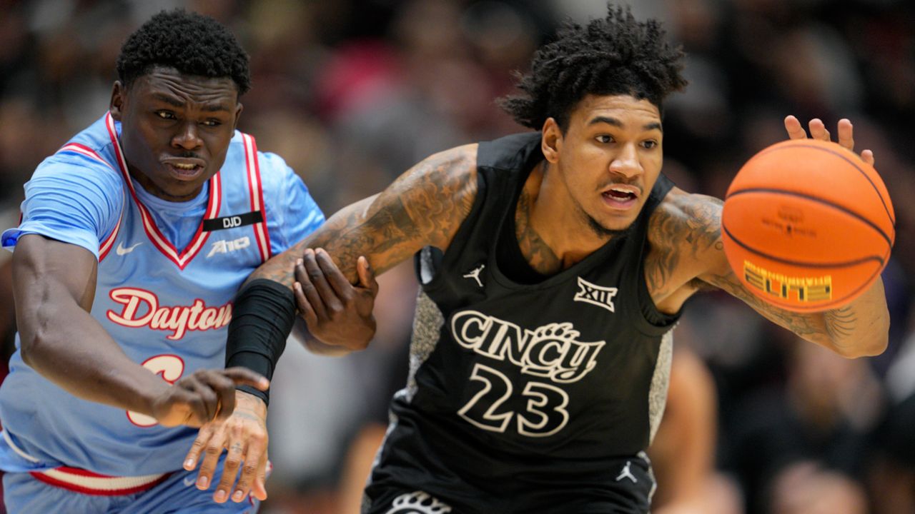 Cincinnati forward Dillon Mitchell (23) chases the ball against Dayton guard Enoch Cheeks, left, during the first half of an NCAA college basketball game, Friday, Dec. 20, 2024, in Cincinnati.