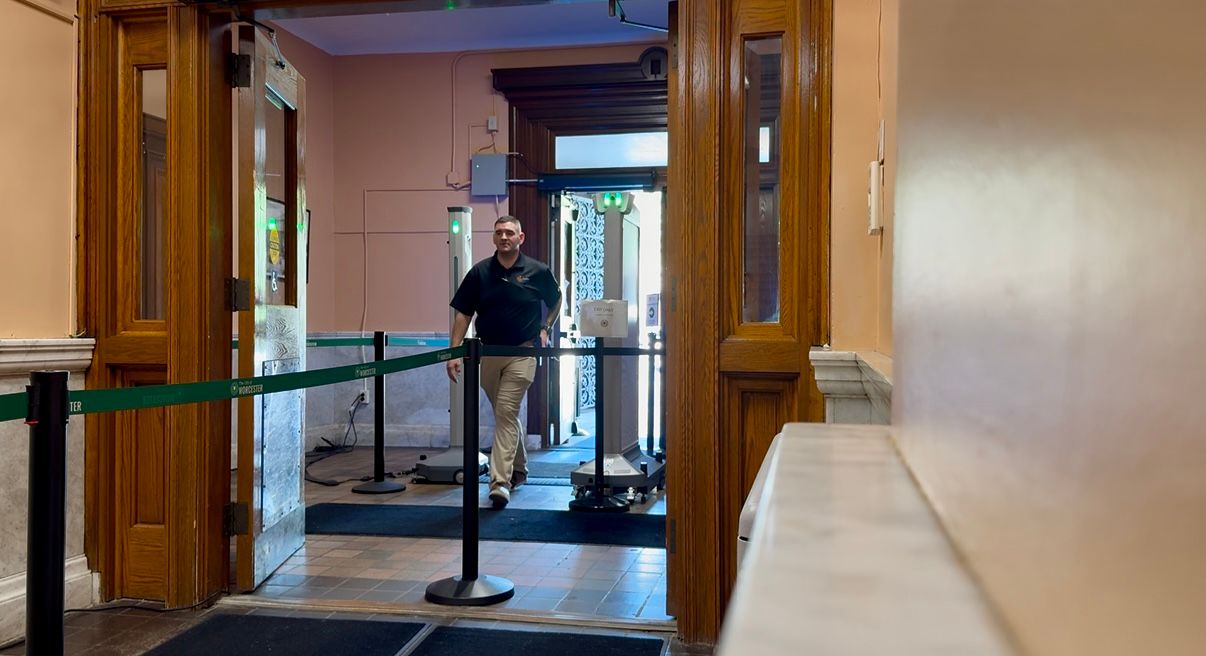 City employee Charles Goodwin passes through the new security scanner at Worcester City Hall. (Spectrum News 1/Meghan Parsons)