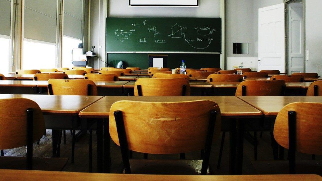 A large, empty classroom, lit by morning light.