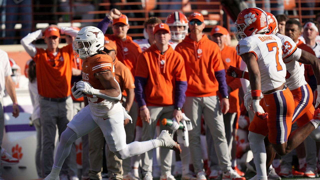 Texas running back Jaydon Blue, left, runs from Clemson safety Khalil Barnes (7) during a 38-yard touchdown run in the first half in the first round of the College Football Playoff, Saturday, Dec. 21, 2024, in Austin, Texas. (AP Photo/Eric Gay)