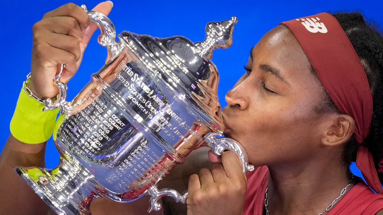 Coco Gauff, of the United States, poses for photographs after defeating Aryna Sabalenka, of Belarus, at the women's singles final of the U.S. Open tennis championships, Saturday, Sept. 9, 2023, in New York. (AP Photo/John Minchillo)