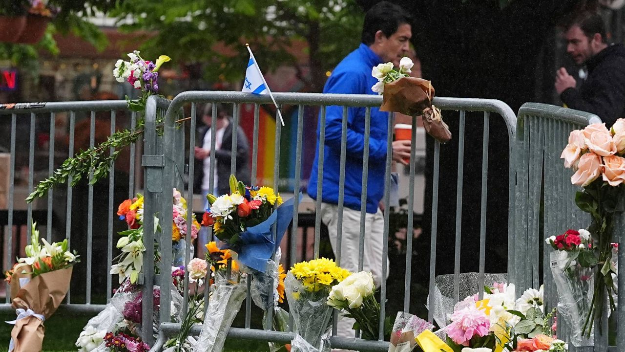 Bouquets of flowers stand along a makeshift memorial for victims of an attack outside of the Boulder County, Colo., courthouse as a light rain falls Tuesday, June 3, 2025, in Boulder, Colo. (AP Photo/David Zalubowski)