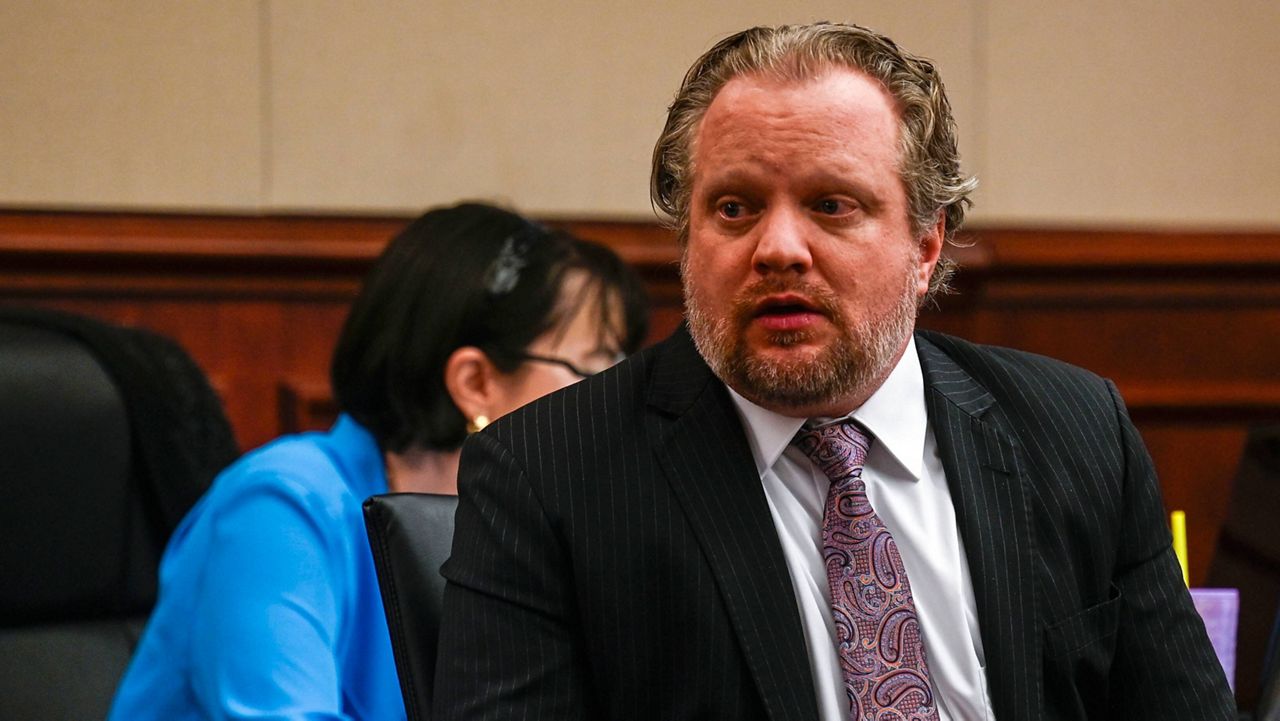James Craig talks with his family from his seat before opening arguments in his murder trial, as he is accused of killing his wife, at the Arapahoe District Court, Tuesday, July 15, 2025, in Centennial, Colo. (Stephen Swofford via Denver Gazette, Pool) 