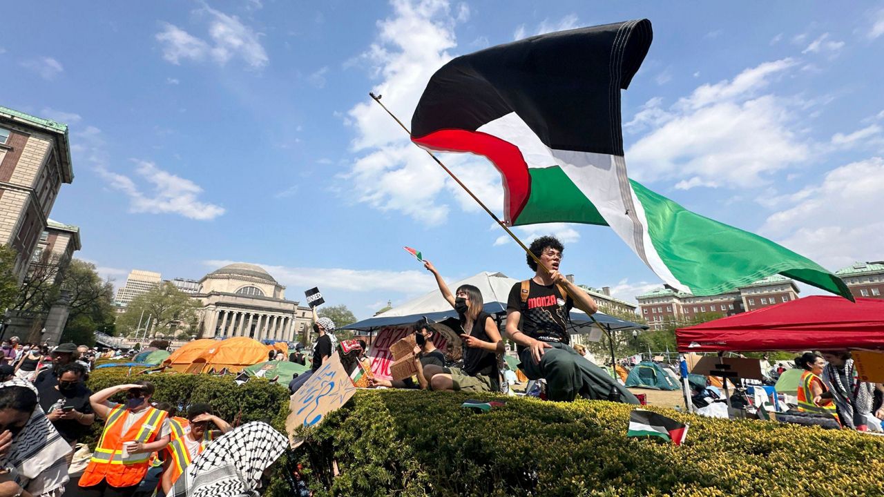 A demonstrator waves a flag on the Columbia University campus at a pro-Palestinian protest encampment, in New York, April 29, 2024. (AP Photo/Ted Shaffrey, File)