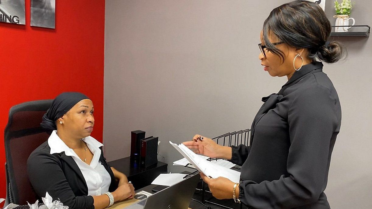Glynis Toler-Manns and her assistant going over paperwork (Spectrum News 1/Zyneria Byrd)