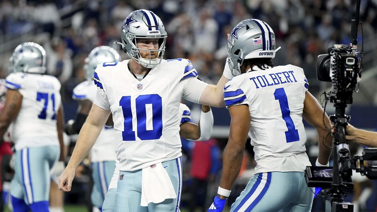 Dallas Cowboys quarterback Cooper Rush (10) and wide receiver Jalen Tolbert (1) celebrate after Tolbert's touchdown catch in the first half of an NFL football game against the Tampa Bay Buccaneers in Arlington, Texas, Sunday, Dec. 22, 2024. (AP Photo/Jeffrey McWhorter)