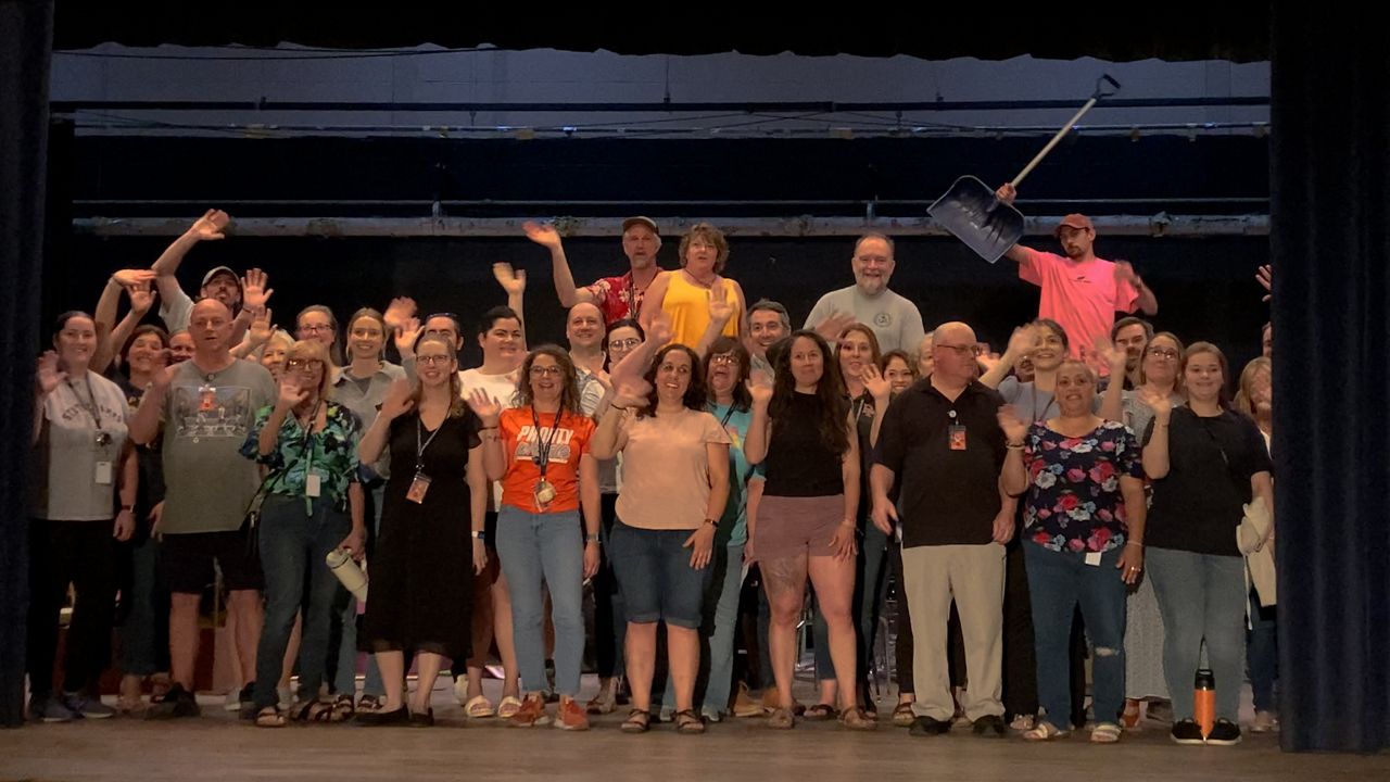 Teachers and staff at David Prouty High School pose for one last photo in the old building on Monday. (Spectrum News 1/Devin Bates)