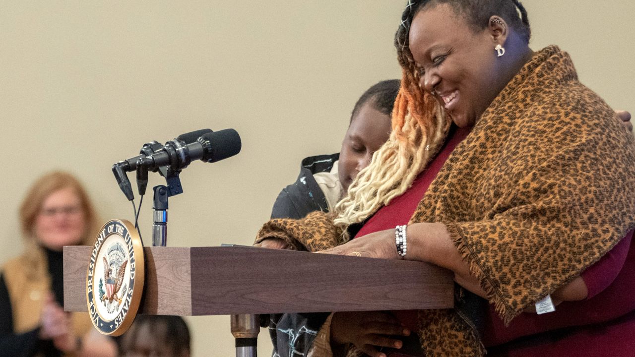 Activist Deanna Branch, of Milwaukee, Wis., is hugged by her son Aiden, 9, who was seriously impacted by lead exposure in his water, with her son Jaden, 12, in the background, as she introduces Vice President Kamala Harris during an event, Friday, Jan. 27, 2023, about lead pipes, water, and health, at the Eisenhower Executive Office Building on the White House complex in Washington. (AP Photo/Jacquelyn Martin)