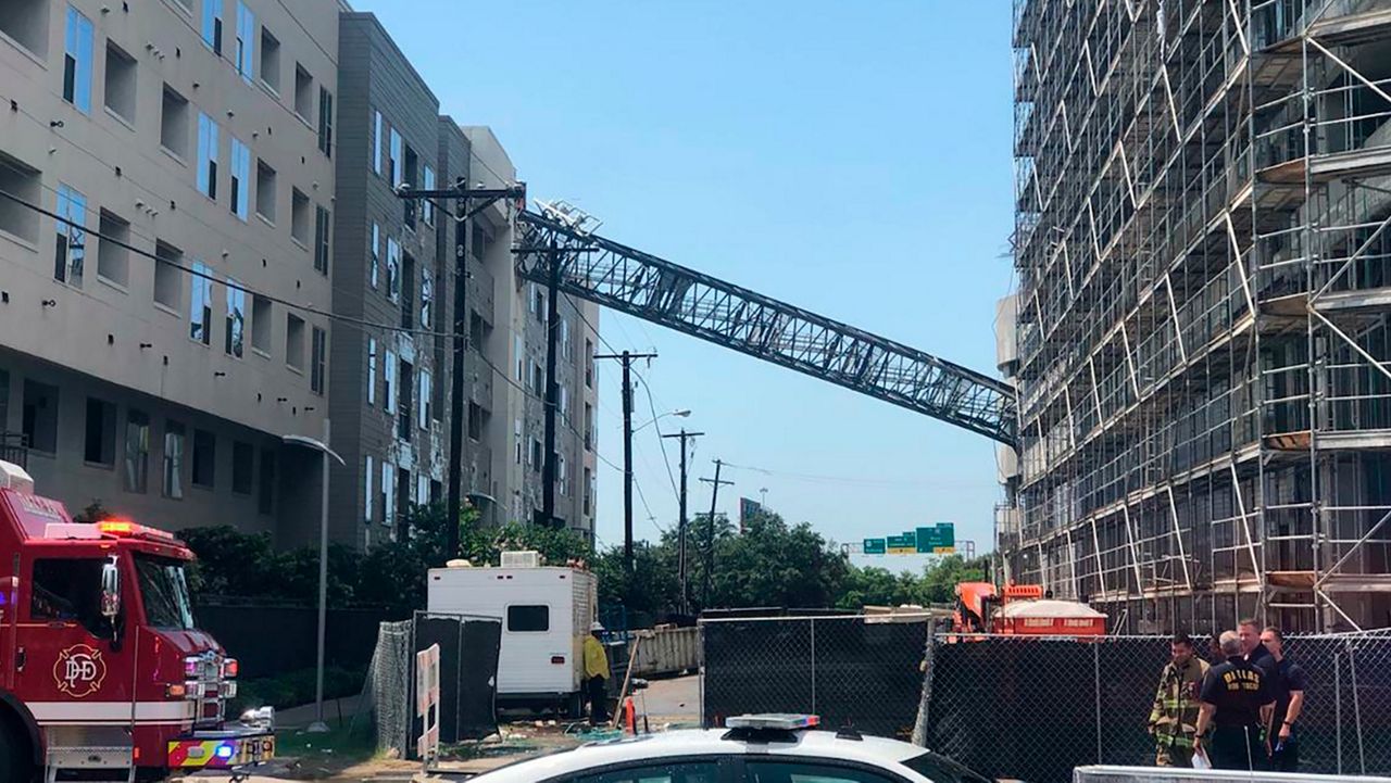 This photo taken and provided by Michael Santana shows a construction crane toppling on an apartment building as it was buffeted by high winds during a storm in Dallas, Texas, Sunday, June 9, 2019. (Michael Santana via AP)