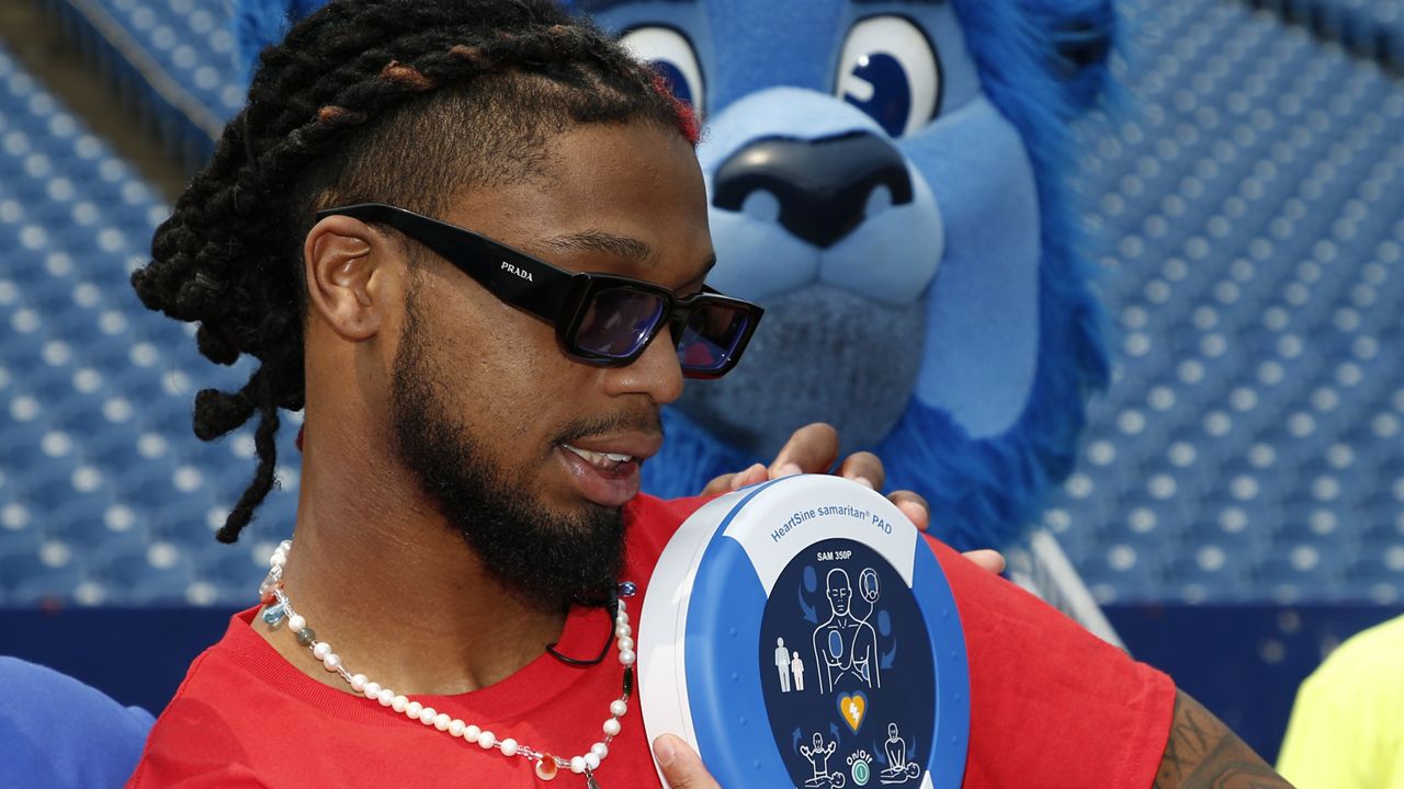 Buffalo Bills defensive back Damar Hamlin poses with a AED (Automatic Electronic Defibrillator) to help resuscitate heart attack victims, to local community groups following the announcement of the first program of his Chasing M's Foundation, the Chasing M's Foundation CPR Tour, Saturday, June 3, 2023, in Orchard Park, N.Y. (AP Photo/Jeffrey T. Barnes)