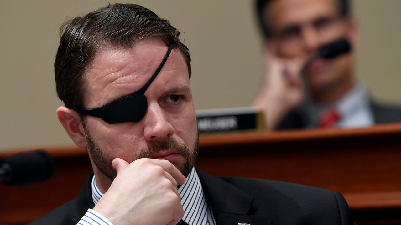 In this Tuesday, March 12, 2019, photo, U.S. Rep. Dan Crenshaw, R-Texas, listens as Office of Management and Budget Acting Director Russell Vought testifies before the House Budget Committee on Capitol Hill in Washington. (AP Photo/Susan Walsh, File)