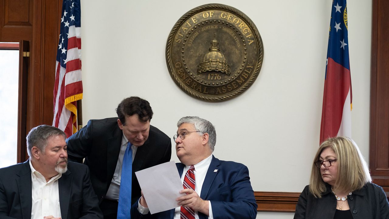 Then-Georgia Republican Party Chairman David Shafer (sitting) consults with Donald Trump reelection campaign lawyer Ray Smith during a meeting of Republican electors who cast votes for Trump and Vice President Mike Pence at the Georgia Capitol, Dec. 14, 2020, in Atlanta. The meeting of the electors has become a key element in the prosecution of Trump and 18 others in Georgia. Shafer and Smith are two of the four people present that day who was indicted by a Fulton County grand jury in August 2023 on charges that he conspired to illegally overturn Democrat Joe Biden's win in Georgia. (AP Photo/Ben Gray, File)