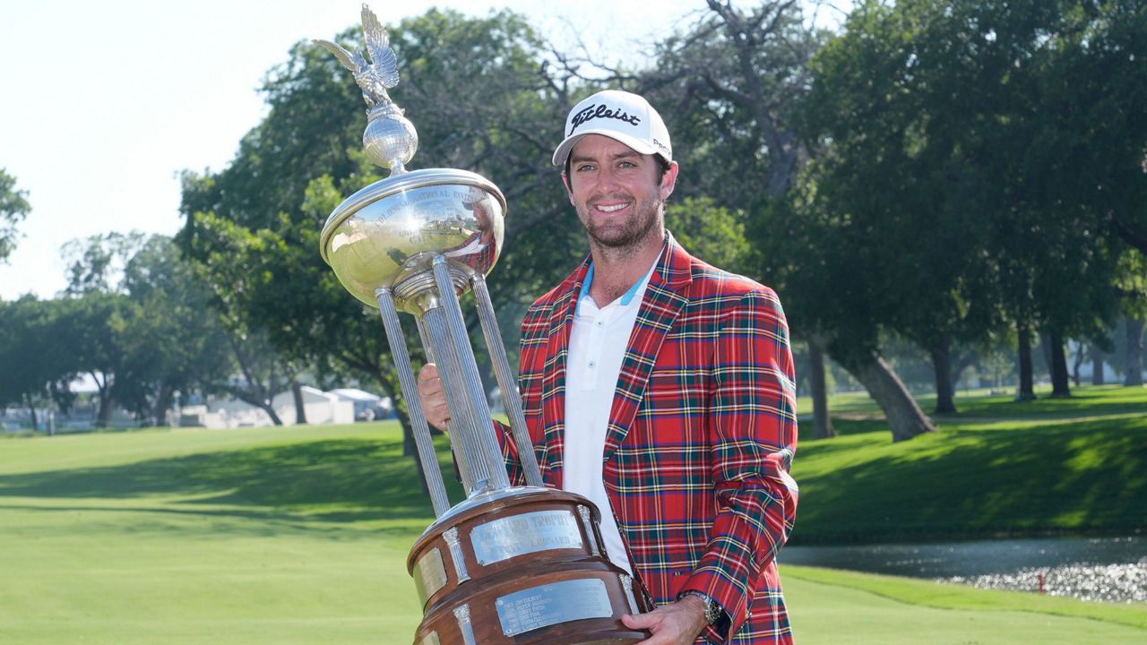 Davis Riley poses with the winner's trophy at the Charles Schwab Challenge golf tournament at Colonial Country Club in Fort Worth, Texas, Sunday, May 26, 2024. (AP Photo/LM Otero