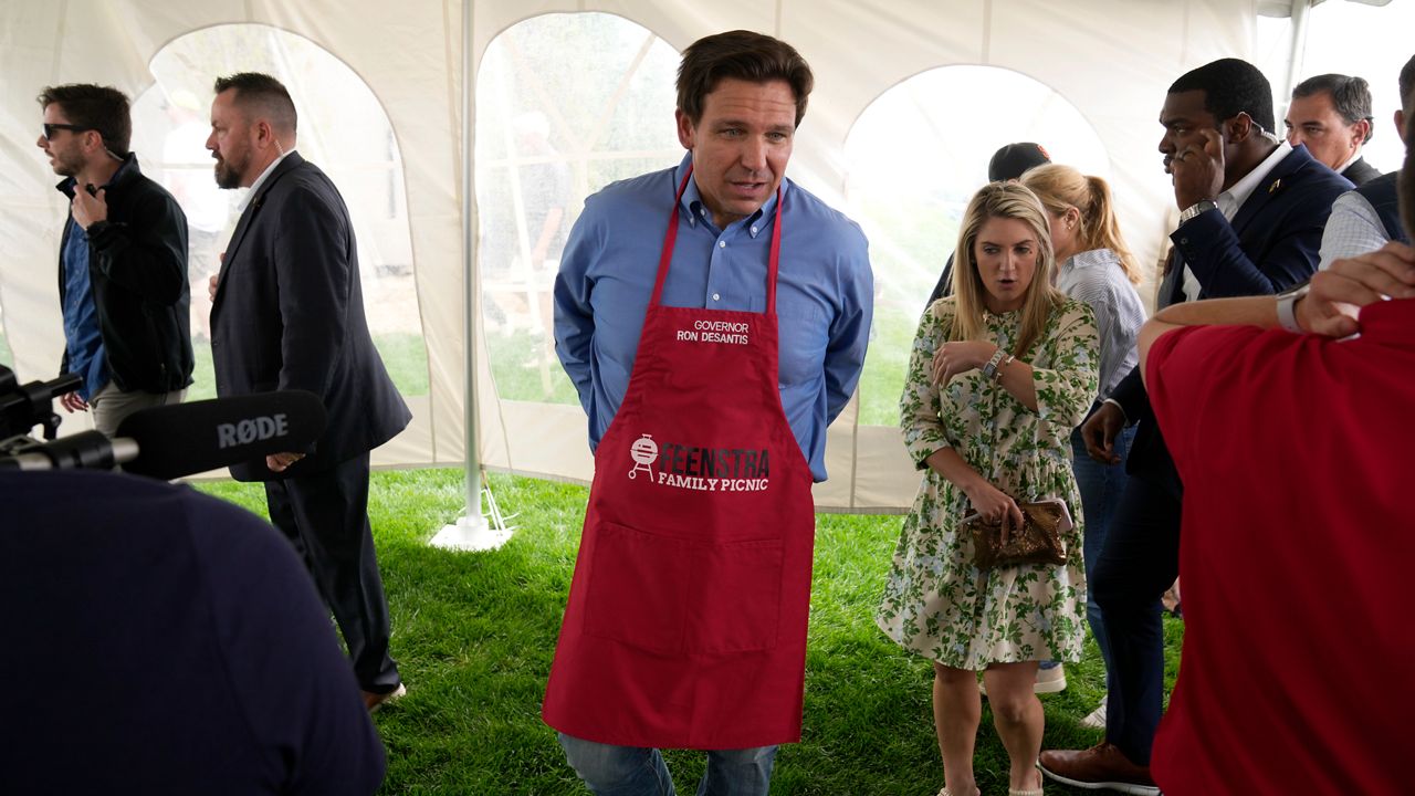 Florida Gov. Ron DeSantis takes off an apron after working the grill at a fundraising picnic for U.S. Rep. Randy Feenstra, R-Iowa, Saturday, May 13, 2023, in Sioux Center, Iowa. (AP Photo/Charlie Neibergall)