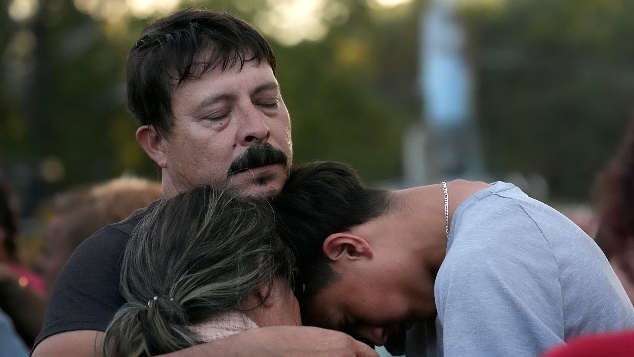 Daniel Delgado, top, is comforted by his 16-year-old son Angel Delgado, right, as he mourns the loss of his wife and Angel's mother, Monica Hernandez, who died at Impact Plastics during flooding caused by Hurricane Helene in Erwin, Tenn., on Thursday, Oct. 3, 2024. (AP Photo/Jeff Roberson)