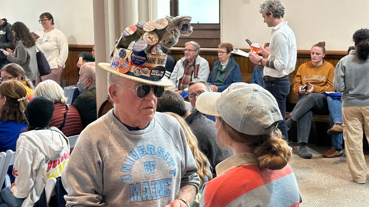 A Democratic supporter speaks to a Troy Jackson staffer on Sunday in Lewiston. (Spectrum News/Susan Cover)
