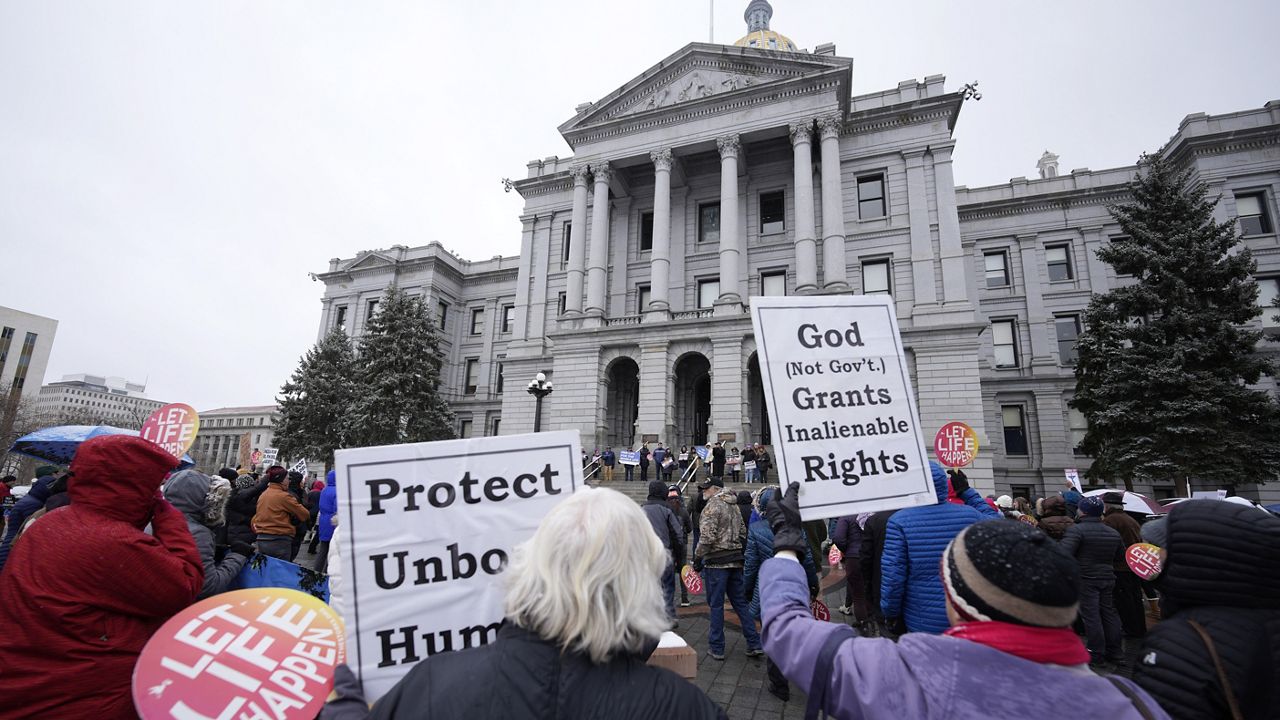 Attendees protest the one-year anniversary of Colorado's abortion law, the Reproductive Health Equity Act, Tuesday, April 4, 2023, outside the State Capitol in downtown Denver. (AP Photo/David Zalubowski, File)