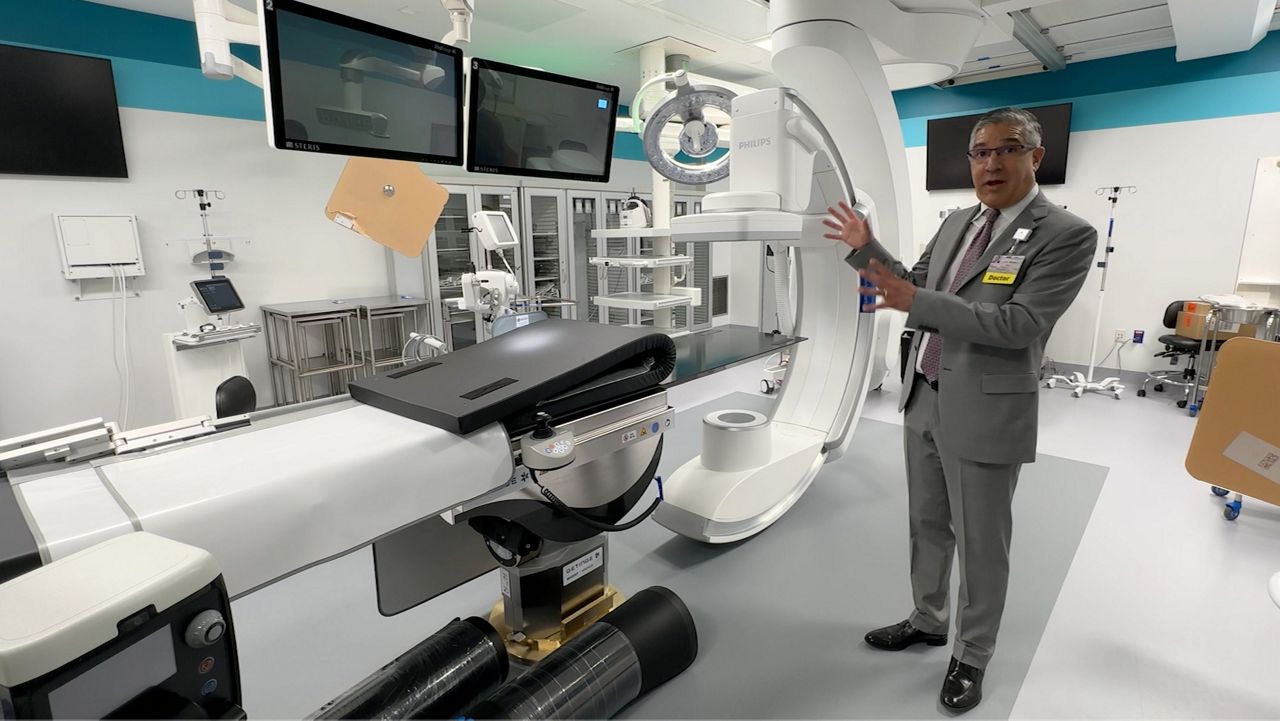 Dr. Marco Diaz, chairperson of Maine Medical Center's department of cardiac services, shows off a "hybrid room" at the hospital's newest cardiac care facility in Portland Thursday. The room can perform any number of modern-day heart scans, work as a catheterization lab, and even be converted into a full-blown operating theater. (Spectrum News/Sean Murphy)