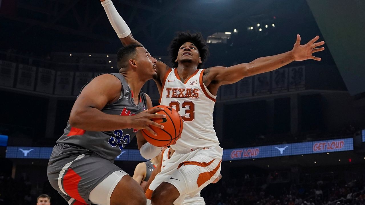 Houston Christian forward Sam Hofman (33) looks to shoot against Texas forward Dillon Mitchell (23) during the first half of an NCAA college basketball game, Thursday, Nov. 10, 2022, in Austin, Texas. (AP Photo/Eric Gay)