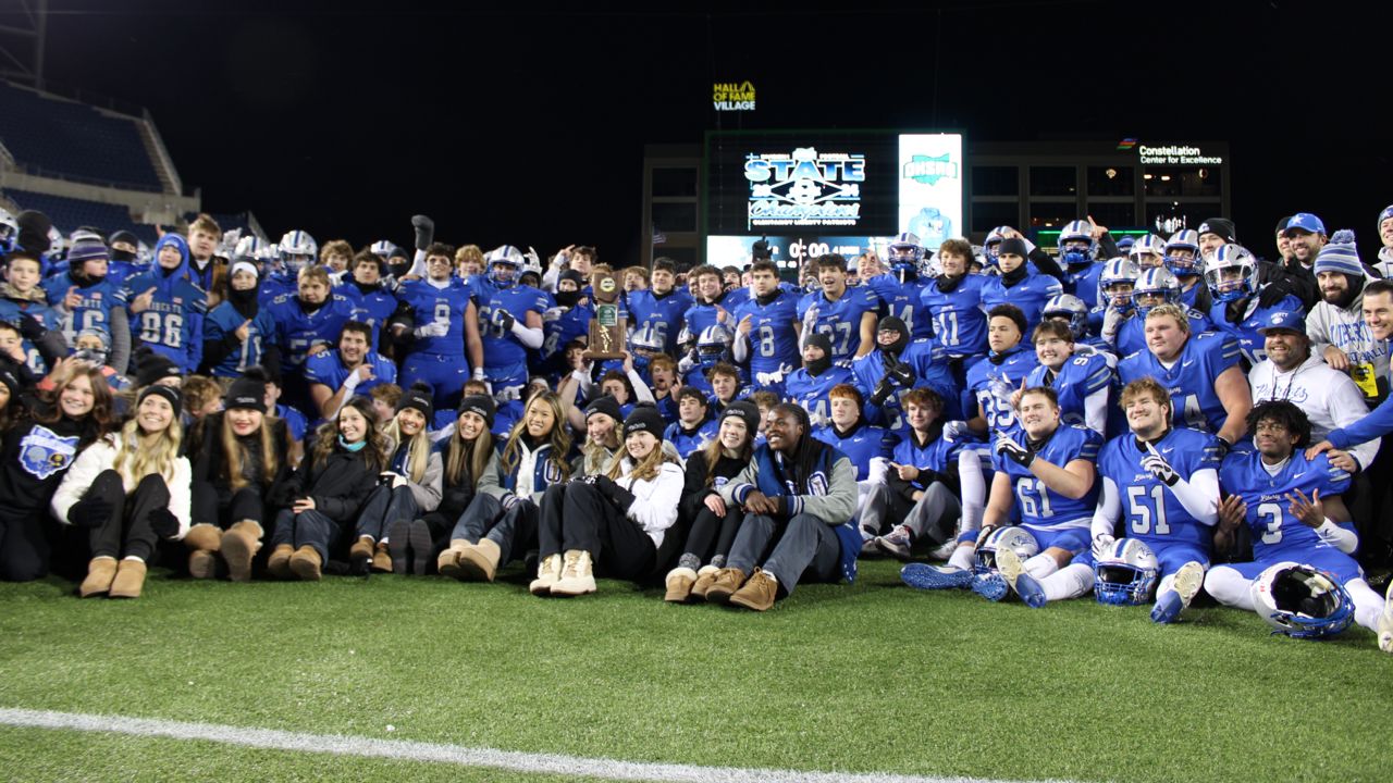 The Powell Olentangy Liberty High School football team and cheerleaders stand with the Division I state championship trophy after the OHSAA Division I football state championship game at Tom Benson Hall of Fame Stadium on Friday.