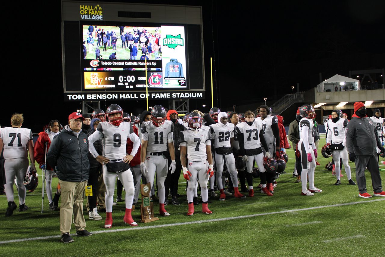 The Toledo Central Catholic High School football team stands with the runner-up trophy after the OHSAA Division III football state championship game at Tom Benson Hall of Fame Stadium on Friday.