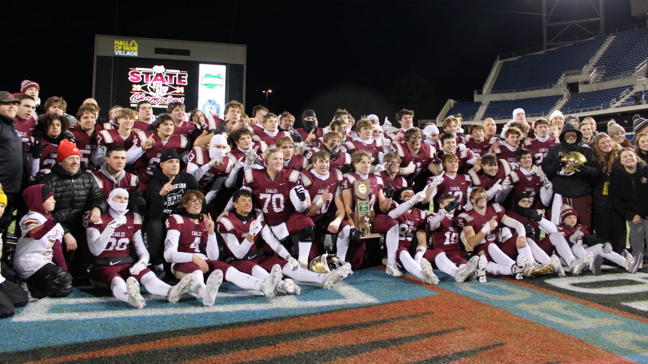 The Columbus Bishop Watterson High School football team receives the state championship trophy after the OHSAA Division III football state championship game at Tom Benson Hall of Fame Stadium on Friday. 