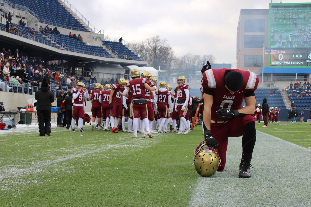 Columbus Bishop Watterson senior Jake Uhlenhake kneels and bows his head before the OHSAA Division III football state championship game at Tom Benson Hall of Fame Stadium on Friday.