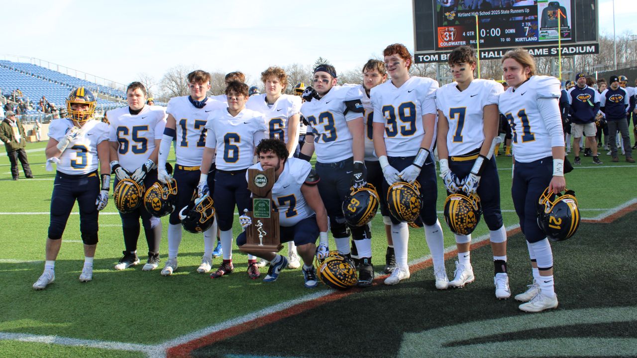 The Kirtland High School football team receives the state runner-up trophy after the OHSAA Division VI football state championship game at Tom Benson Hall of Fame Stadium on Saturday.